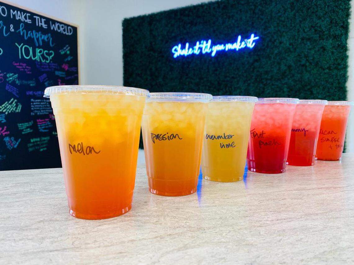 Teas in a variety of flavors are on the menu at The Healthy Hub at First Street and Barstow Avenue. A neon “Shake it til you make it” sign is in the background.