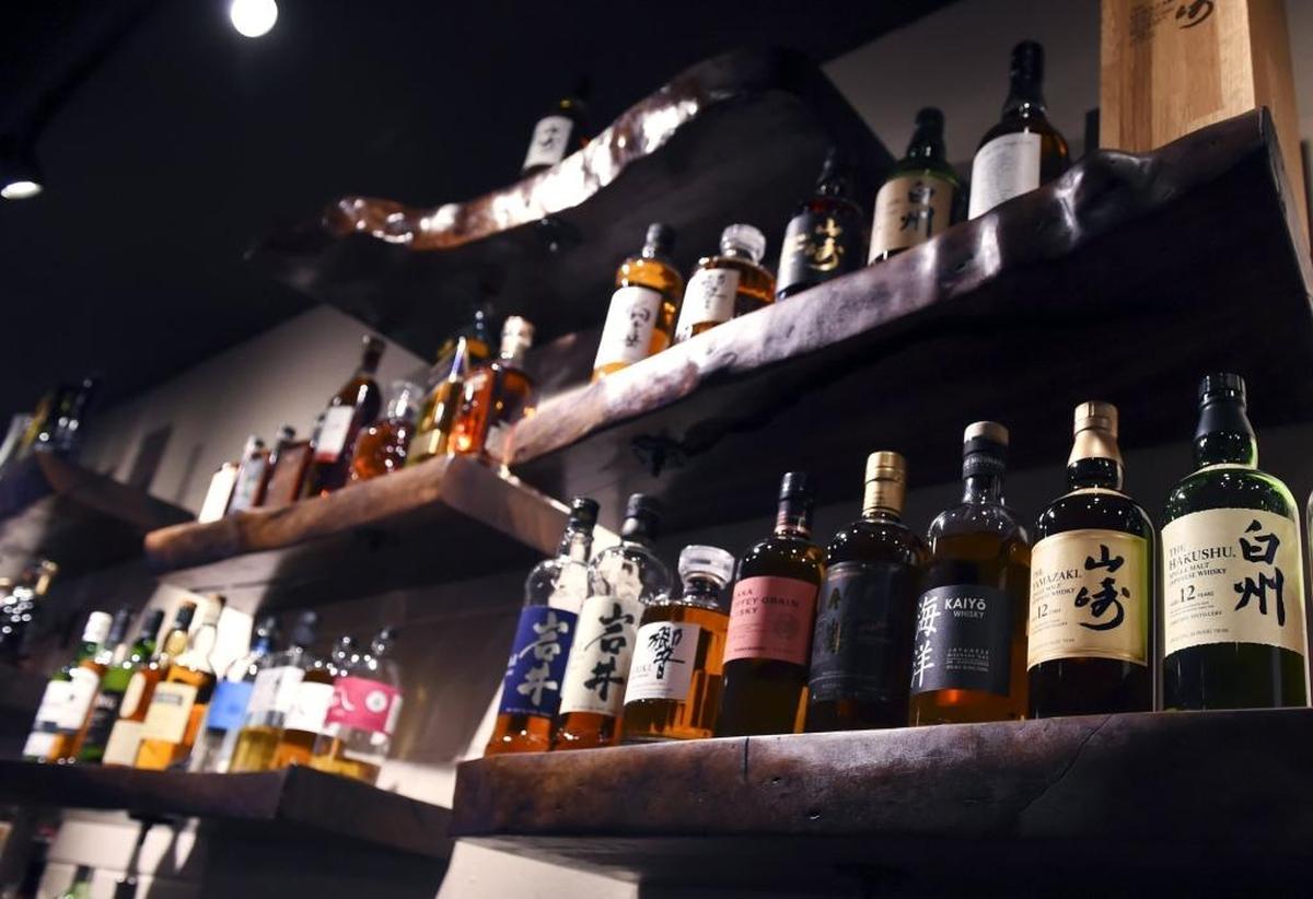 Japanese fine whiskeys are among the liquor displayed on walnet shelves at Tamari Robatayaki & Whiskey Bar.