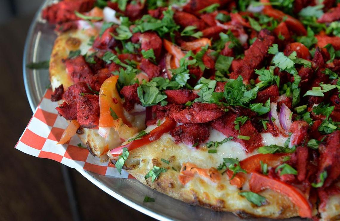 A tandoori chicken masala pizza are displayed on trays at The Curry Pizza Company at the restaurant in Fresno on Thursday, June 7, 2018.