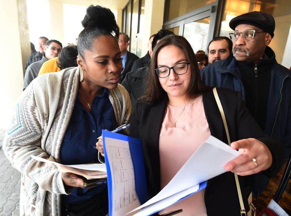 Job applicants Tia Mouya, left, and Ulyssa Velaquez, right, go over paperwork as they and hundreds of other job-seekers wait in line up outside DoubleTree hotel for the Amazon job fair in this file photo taken on Tuesday, Jan. 16. 2017. Pardini’s Catering is seeking to fill 200 positions at a job fair Thursday, Aug. 2, 2018.