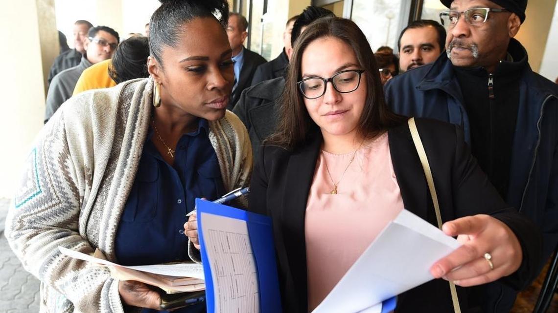 Job applicants Tia Mouya, left, and Ulyssa Velaquez, right, go over paperwork as they and hundreds of other job-seekers wait in line up outside DoubleTree hotel for the Amazon job fair in this file photo taken on Tuesday, Jan. 16. 2017. Pardini’s Catering is seeking to fill 200 positions at a job fair Thursday, Aug. 2, 2018.