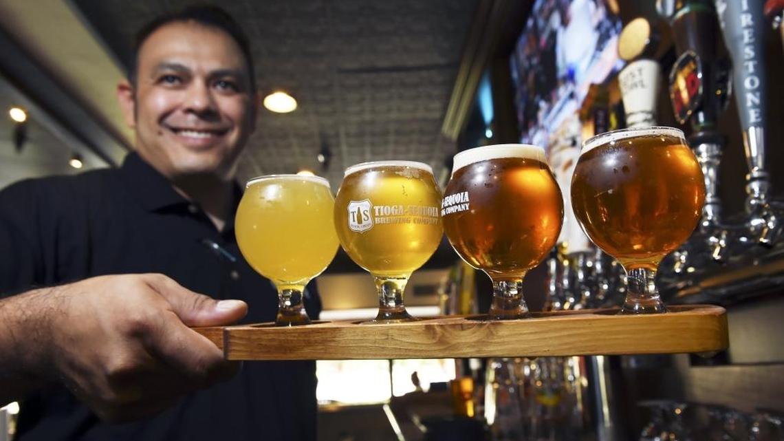 Bartender Eric Garcia presents a flight of beer at Taps & Tacos in Fresno. Taps & Tacos is just one of several places catering to customers with the explosion of beer on tap’s popularity.