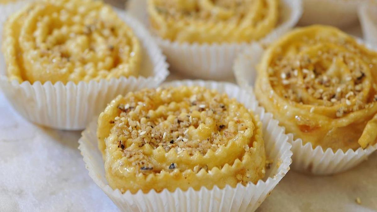 
Topped off with chopped nuts and sesame seeds, golden colored diples, a Greek desert made by frying thin layers of coiled dough, are made for the Fresno Greek Festival at St. George Greek Orthodox Church.
