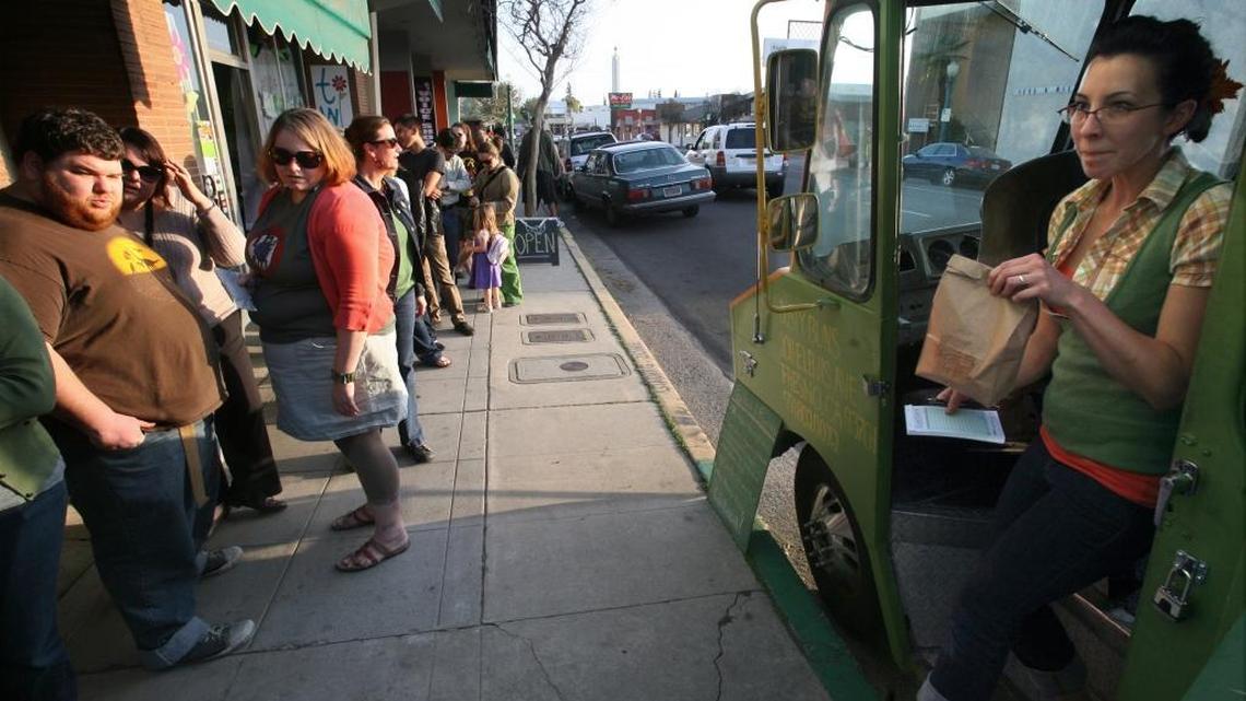 Kristin Stewart of Dusty Buns Bistro Bus, emerges with someone’s dinner as customers wait in line in the Tower District in 2011.