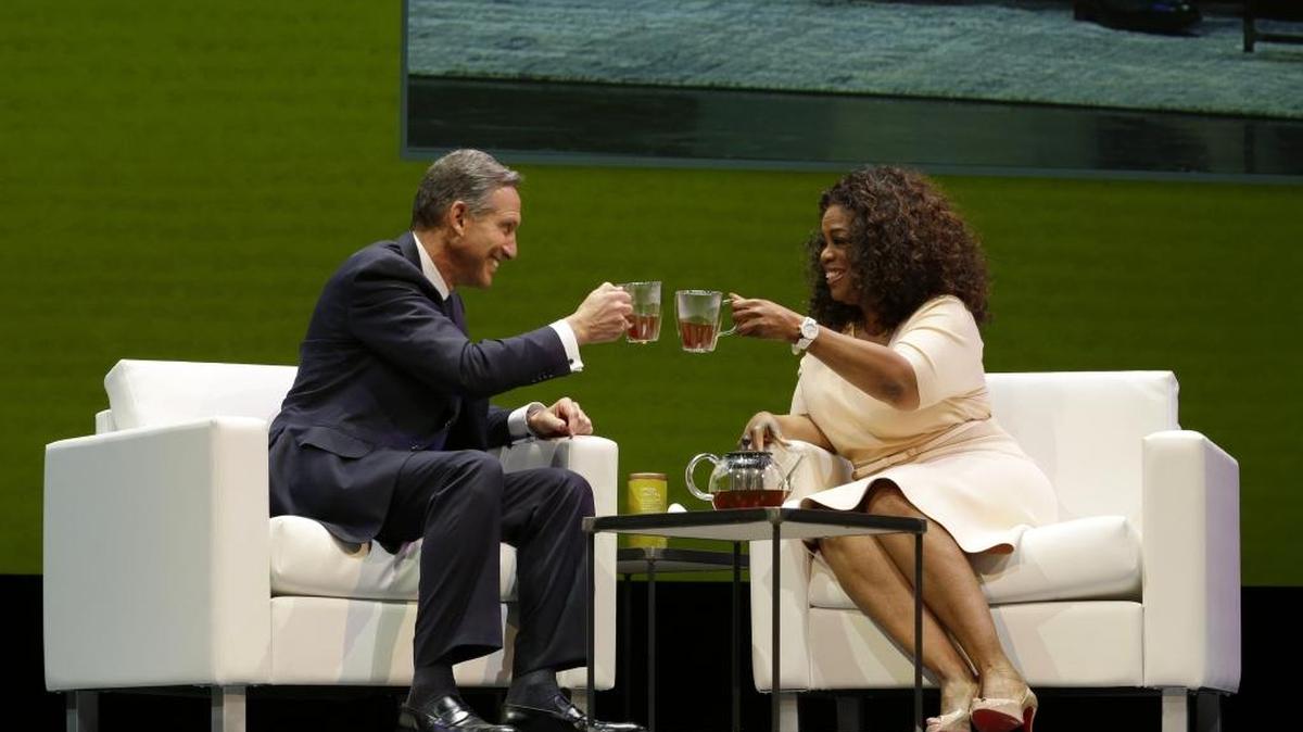 Howard Schultz, left, chairman and CEO of Starbucks Coffee Company, clinks tea cups with Oprah Winfrey, right, to announce their partnership to offer Teavana Oprah Chai tea on Wednesday, March 19, 2014.