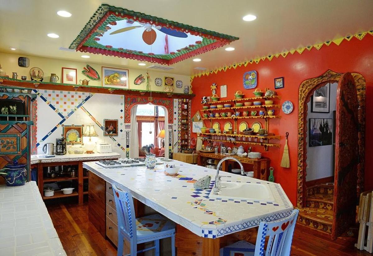 A skylight and kitchen island are the centerpieces of the “fairy tale kitchen” at the Tulip House in Bass Lake, which also includes many colorful mugs and place settings as well as one of several unusual doorways.