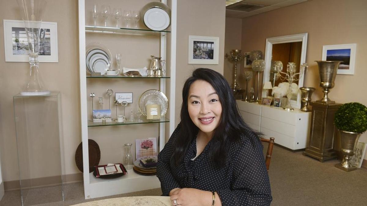 Susan Vang-Xiong, owner of Circle of Events, an event planning business in Fresno, sits in her showroom, which features examples of items her company rents out to clients.