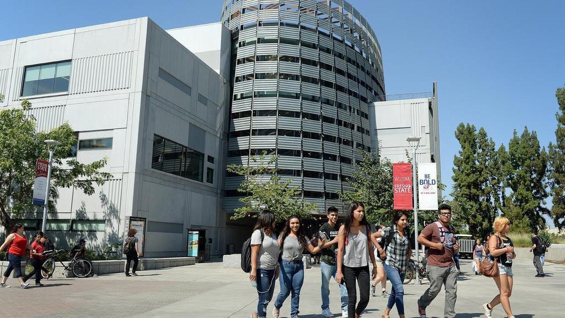 Students cross in front of the Madden Library at Fresno State on the first day of classes in 2017. Today the area is vacant, the result of distance learning brought about by the COVID-19 pandemic.