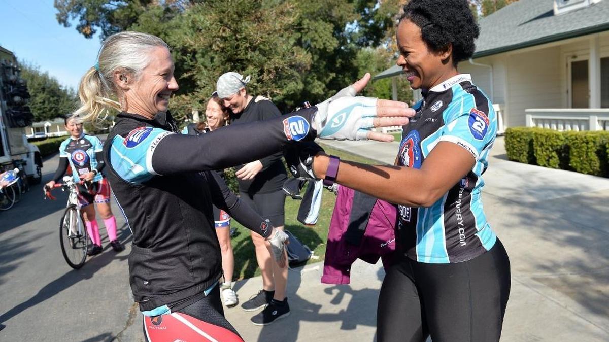 Jen Goodbody, Ride 2 Recovery program events/participants coordinator, left, and Sharika Blockett, 39, of Fayetteville, North Carolina, celebrate after a 8-mile round trip bike ride up a mountain road during a four-day Ride 2 Recovery program at Wonder Valley Ranch Resort and Conference Center.