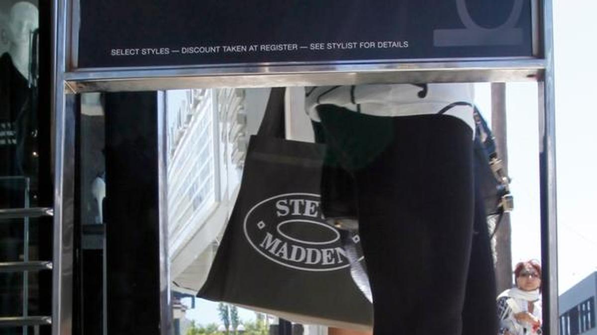 In this Sept. 10, 2010 photo, shoppers carry bags from a bebe store offering big discounts in Santa Monica. The company announced it will close all of its stories, including one in Fresno, by the end of May.