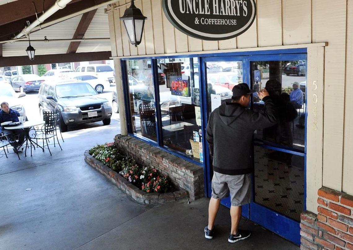 A man peers into Uncle Harry’s New York Bagelry & Coffeehouse in Fig Garden Village which closed its doors April 28.
