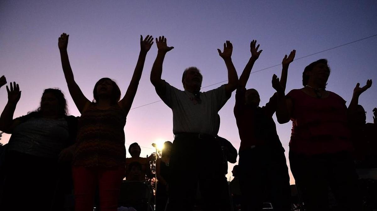People lift their hands in prayer.