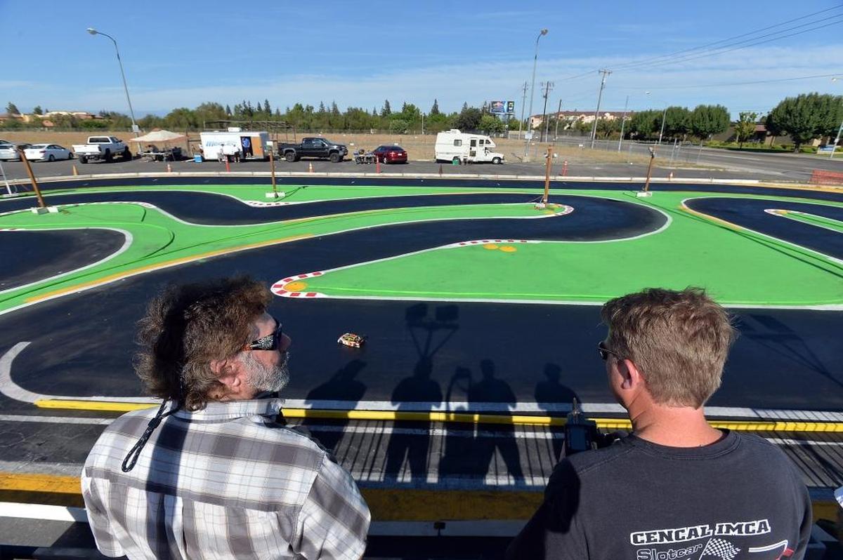 Remote-control race car hobbyists look over the racetrack at HobbyTown USA in Fresno in this file photo from 2018. Every Saturday, up to about 100 area hobbyists race remote cars on the track next door. The store has a new home a few doors down, but is still using the track.