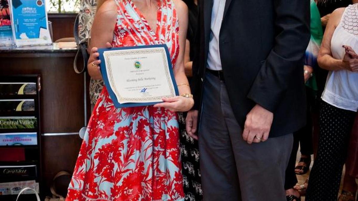 Jennifer Elizondo Speck, owner of Blooming Belle Marketing with Nathan Ahle, Fresno Chamber president and CEO, during a ribbon cutting at the Fresno Chamber of Commerce.