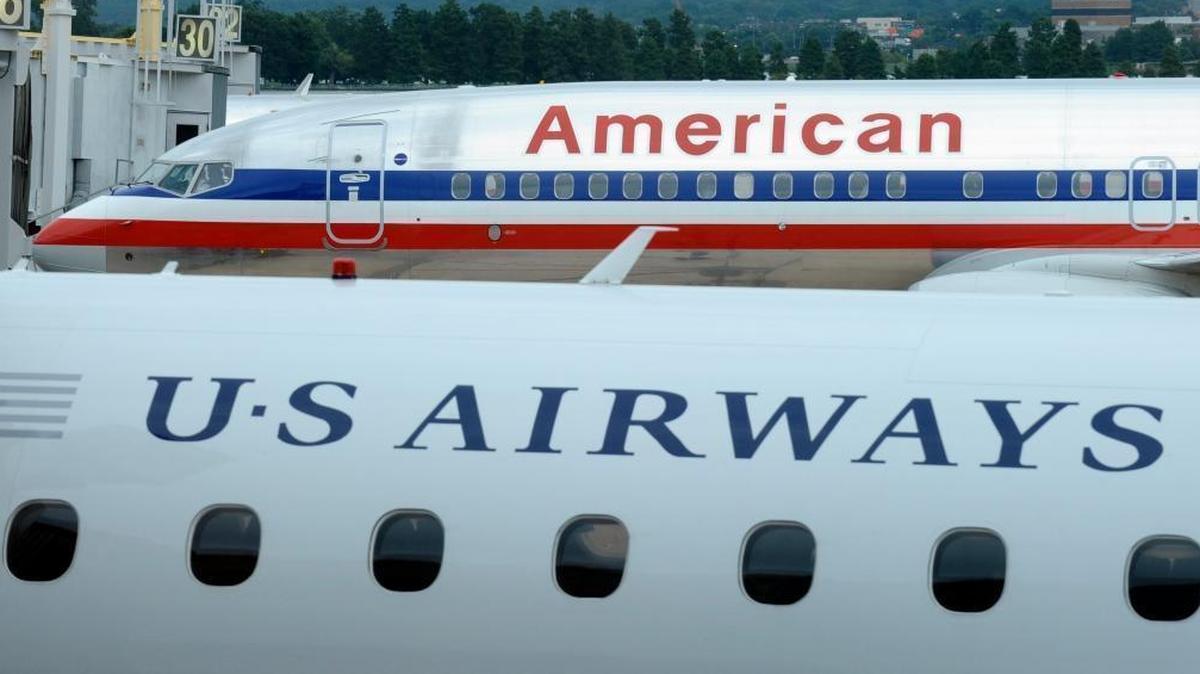 An American Airlines plane and a US Airways plane sit at Washington's Ronald Reagan National Airport in this file photo. American announced a scheduling problem that inadvertently gave pilots time off during the holidays. The airline Wednesday was working to get enough pilots to cover flights. Unknown was how departures and arrivals at Fresno Yosemite International airport might be affected.