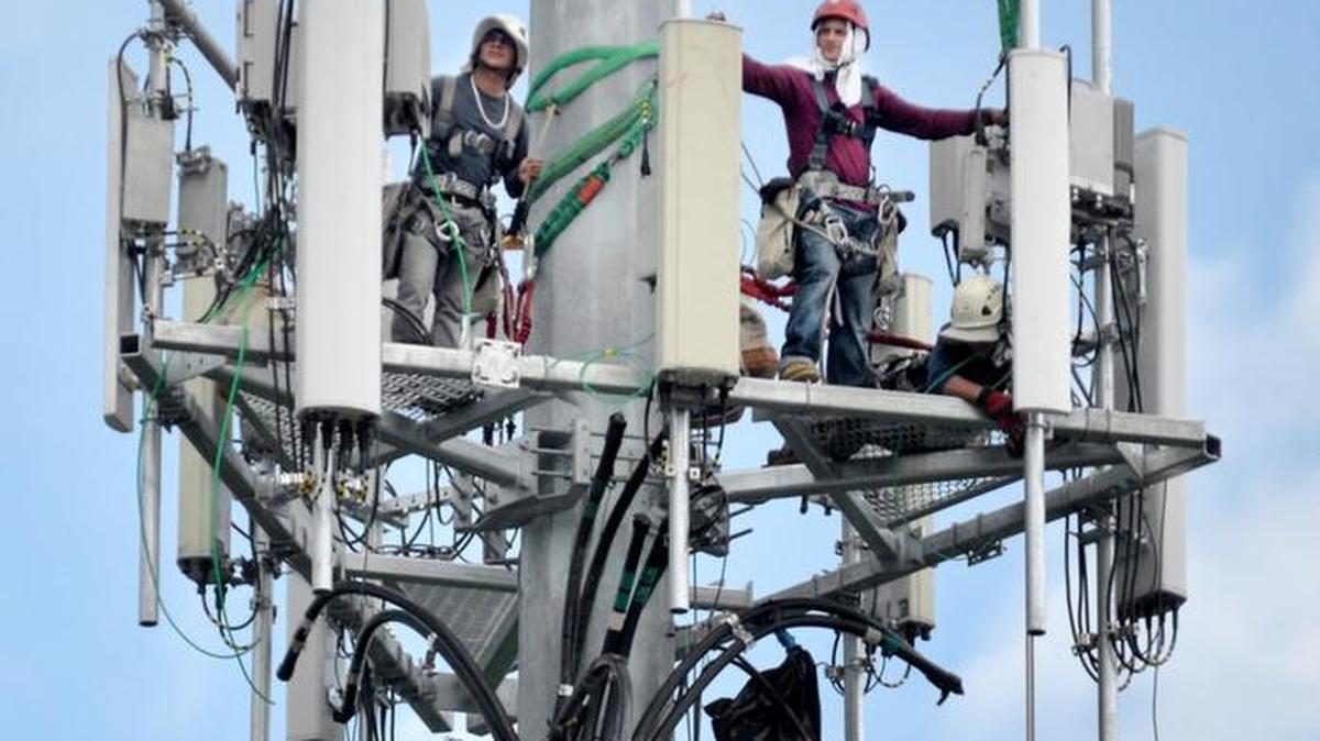 
Workers install upgraded equipment on a cellular tower in Georgia in August.
