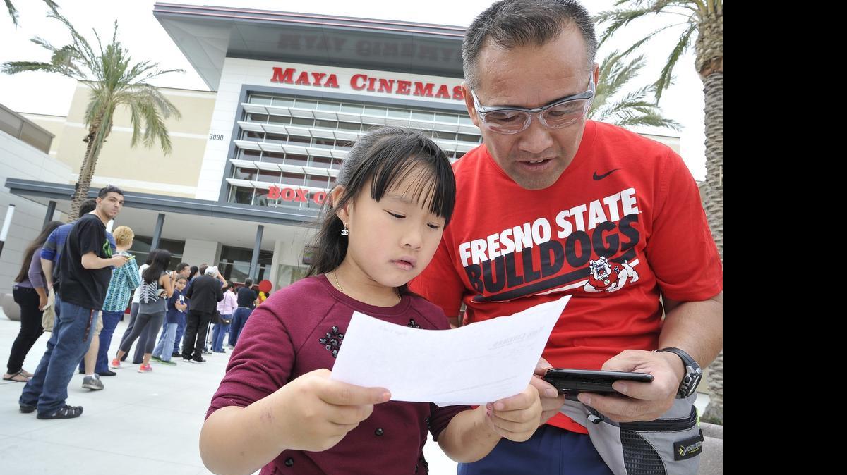 
Larry Ounkham and daughter, Selena, 6, decide what movie to see as they wait in line at the Maya Cinemas during its grand opening Friday afternoon, May 22, 2015.
