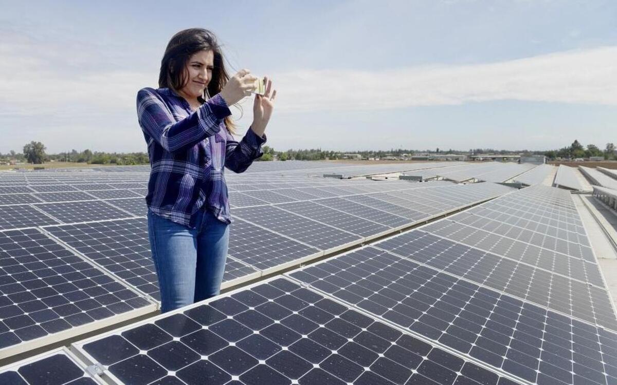 Sierra Lopes, marketing specialist at Baloian Farms in Fresno, photographs the company’s new solar panels that nearly cover the 108,000 square feet of roof space on the company’s packing and cooling plant, Thursday, April 14. The company recently completed installation of 3,370 solar panels.