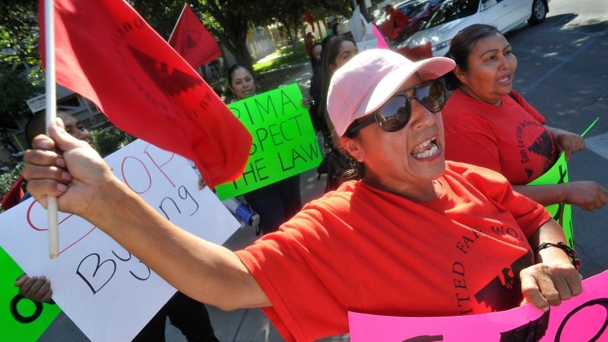 Lourdes Cardenas waves a UFW flag as she and others protest alleged intimidation by Gerawan Farming, in front of the state building in 2014.
