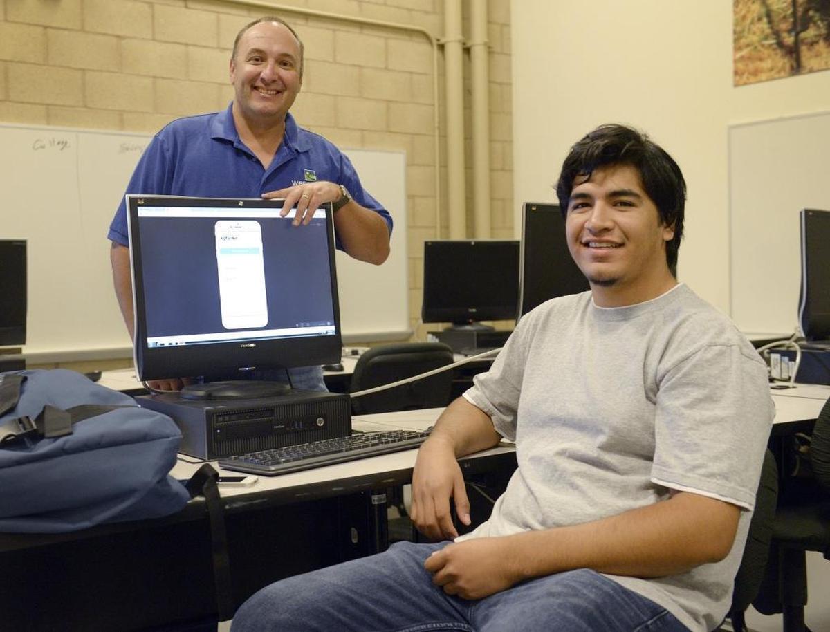 Ag For Hire app student/creator Alex Avalos, right, and Clint Cowden, director of Farm of the Future at West Hills Community College in Coalinga, sit with a computer model of the app in this 2016 photo.