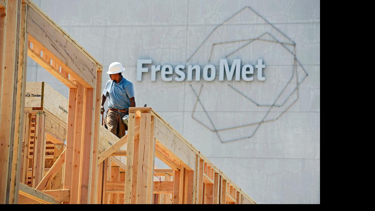 
A construction worker helps piece together part of the roof of a new residential apartment structure rising up near the old Fresno Met building in downtown Fresno Tuesday, May 19, 2015.
