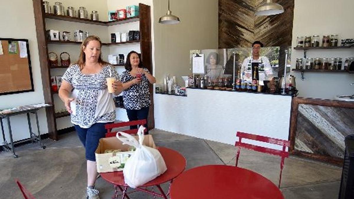 Corey Francis, left, and Michelle Abenoja pick up fresh teas at Raizana Tea Company in downtown Fresno on July 23, 2015.