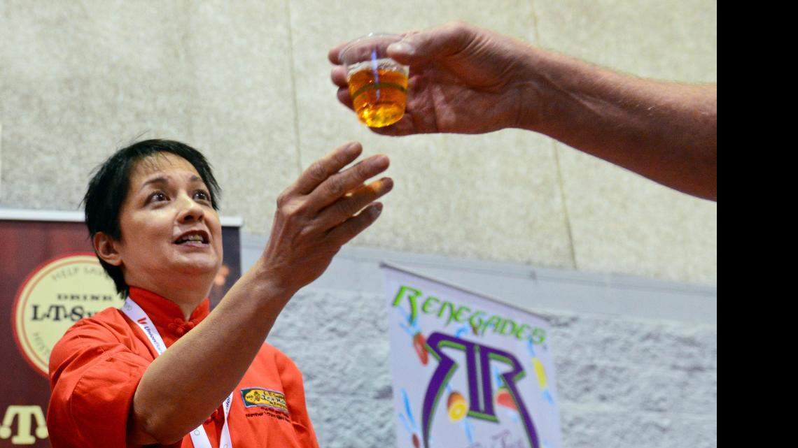 
Arianne Wing of the L.T. Sue Company from Hanford, hands out samples of one of the company’s teas at the 2014 Fresno Food Expo at the Fresno Convention Center. This year organizers are expecting a record number of buyers to attend the expo that is featuring more than 100 local companies. 
