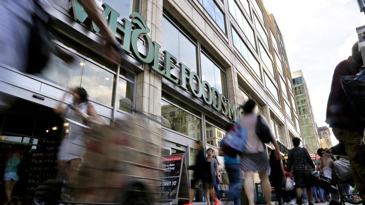 Pedestrians pass in front of a Whole Foods Market store in Union Square in New York in June 2015. The grocery store chain slashed prices Monday, Aug. 28, 2017 – the first day under its new parent company, Amazon.