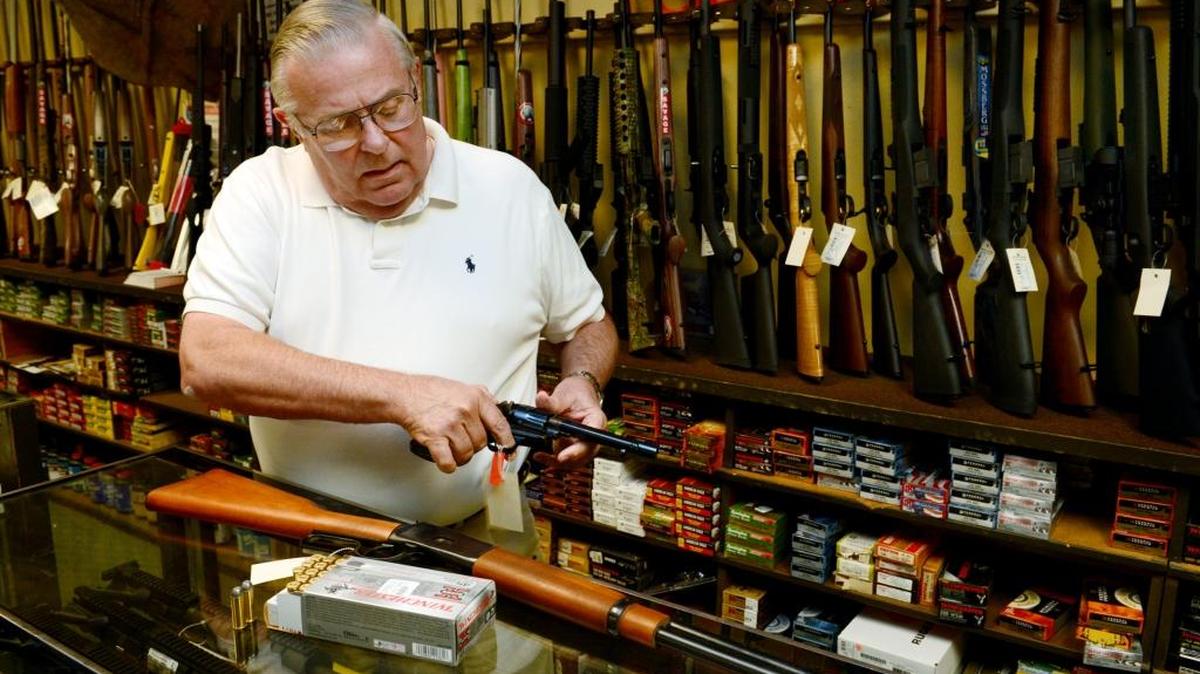 In this file photo, Barry Bauer of Herb Bauer Sporting Goods in Fresno displays guns that sell at his store.