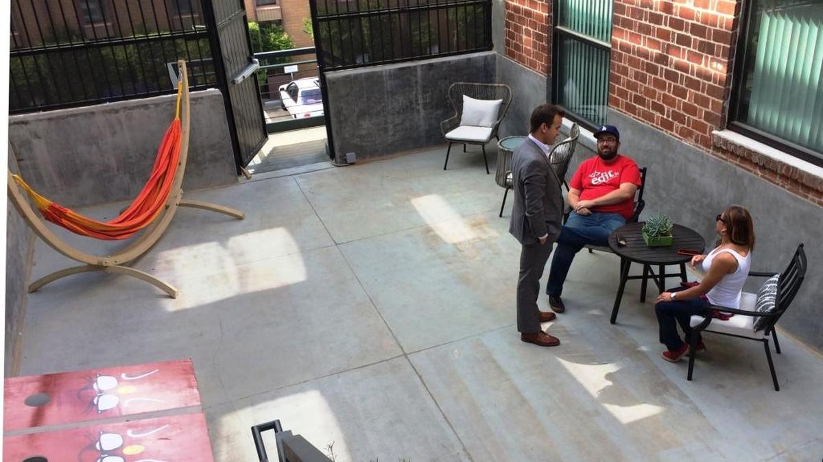 Bitwise Industries CEO Jake Soberal, standing, talks with Hashtag Fresno member Richard Sargent and Jona Agcaoili, seated right, on the rooftop patio area at the Hashtag’s new location in the Hotel Virginia building. Agcaoili was the designer/decorator for Hashtag’s new site that opened April 12.