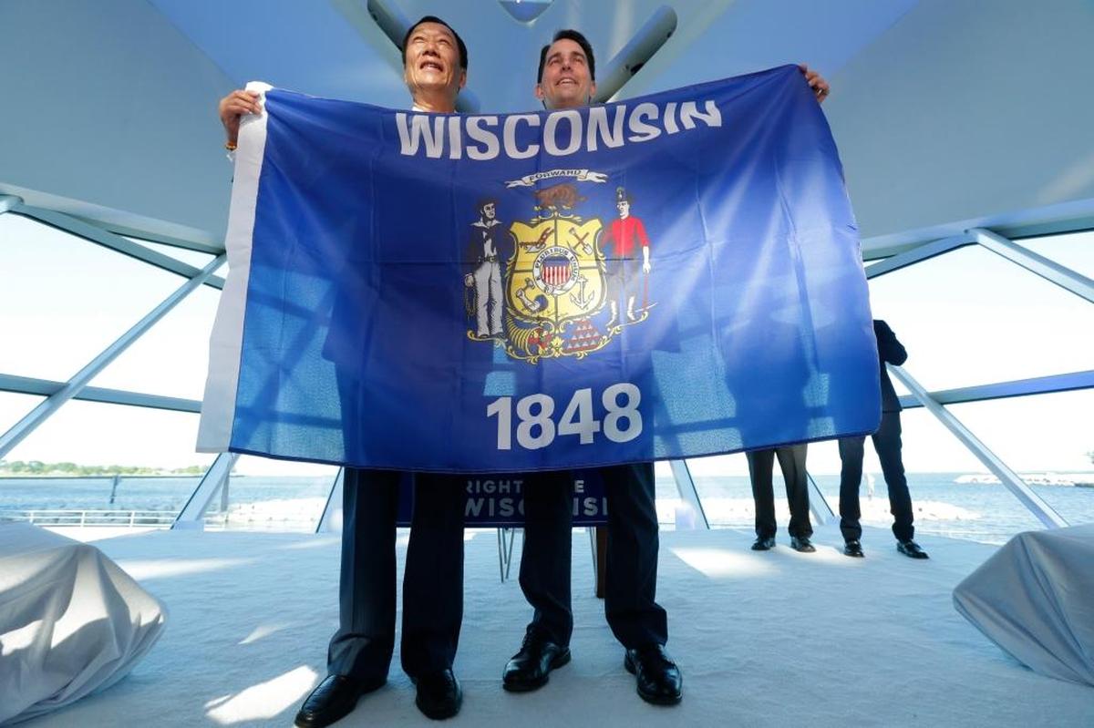 Foxconn Chairman Terry Gou, left, and Gov. Scott Walker hold the Wisconsin flag to celebrate their $10 billion investment to build a display panel plant in Wisconsin, at the Milwaukee Art Museum on Thursday, July 27, 2017.