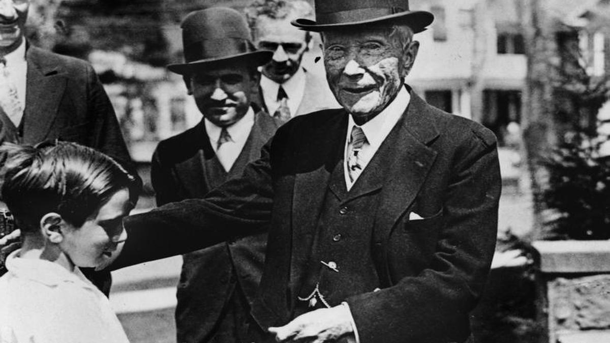 U.S. oil magnate and philantropist John D. Rockefeller gives a dime to a child in this undated picture. An April 2017 article in the Foundation for Economic Education argues that today’s poor are richer than Rockefeller.