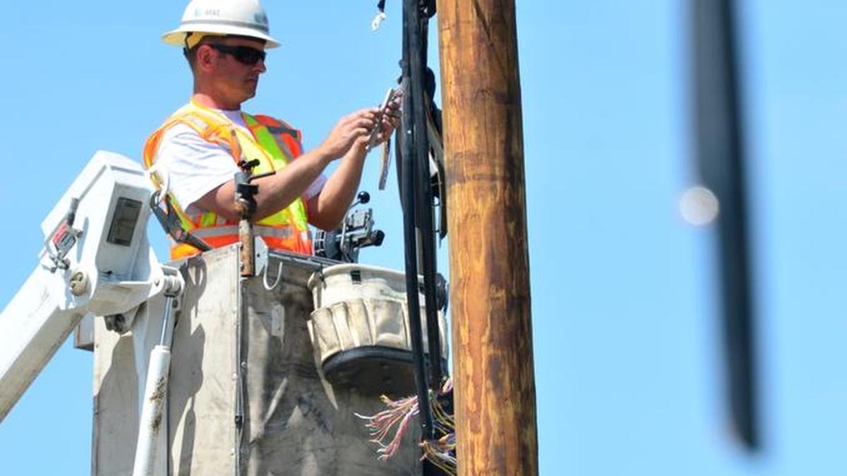 An AT&T splicing technician works to splice 300 wires on a phone line southwest of Fresno during repair work in this 2012 file photo.