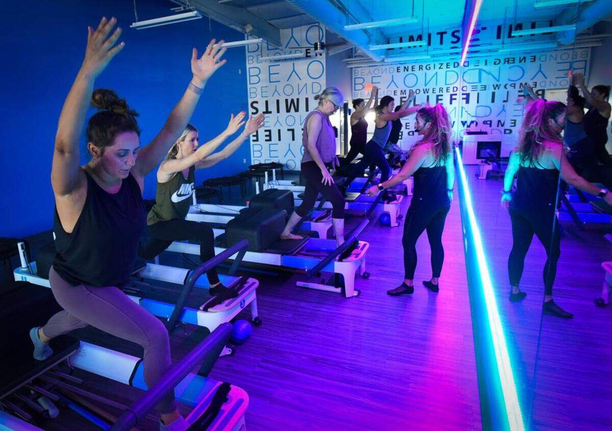 One of the newer businesses in the renovated Trading Post shopping center is the Beyond Pilates Studio, where instructor Heather McCann, center, leads exercises, Friday morning, Aug. 17, 2018.