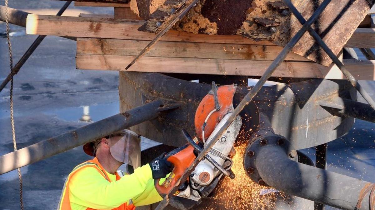 Underneath a giant, rusting impeller, a worker cuts sections of pipe to be removed from a former aeration basin at Fresno’s wastewater treatment plant in this 2015 file photo. The basin is being converted to a reservoir for treated, recycled wastewater that will be piped across the city for landscaping, industry and recharge uses.