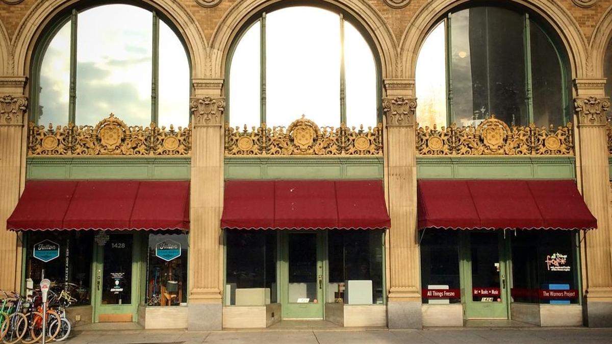 Fulton Cycle Works, which now occupies a single space on the left, is in the process of expanding into the two storefronts next door. The building is part of the historic Warnors Theatre and faces Fulton Street.
