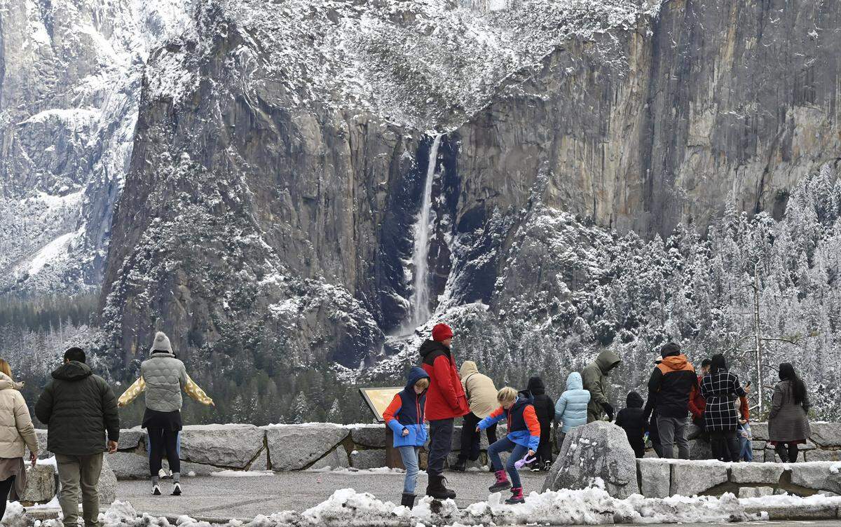 Bridalveil Fall is flowing while the cliffs around Yosemite Valley still show snow from its last snowfall as tourists stop at Tunnel View Friday, Feb 9, 2024, in Yosemite National Park. 