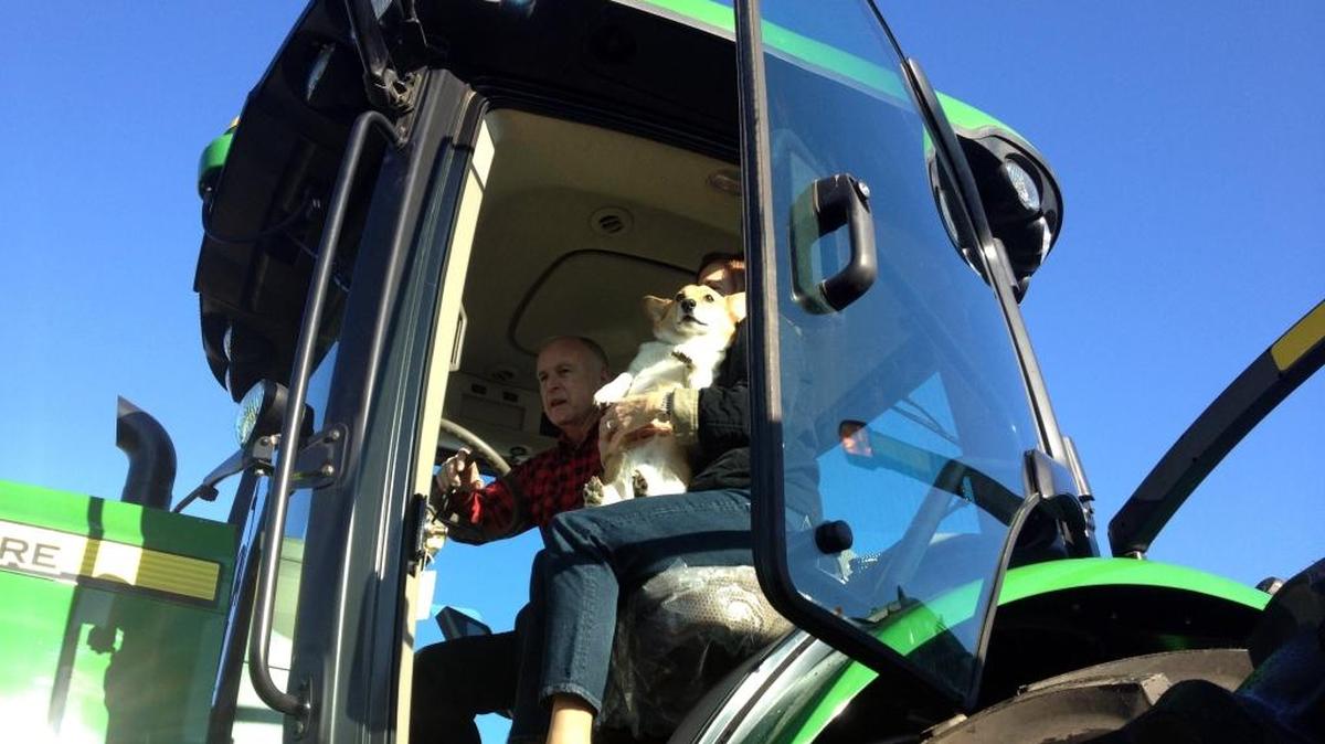 Gov. Jerry Brown poses in the cab of a John Deere tractor with first lady Anne Gust Brown holding their dog Sutter Brown at the Colusa Farm Show on Wednesday, Feb. 6, 2013 in Colusa, Calif.