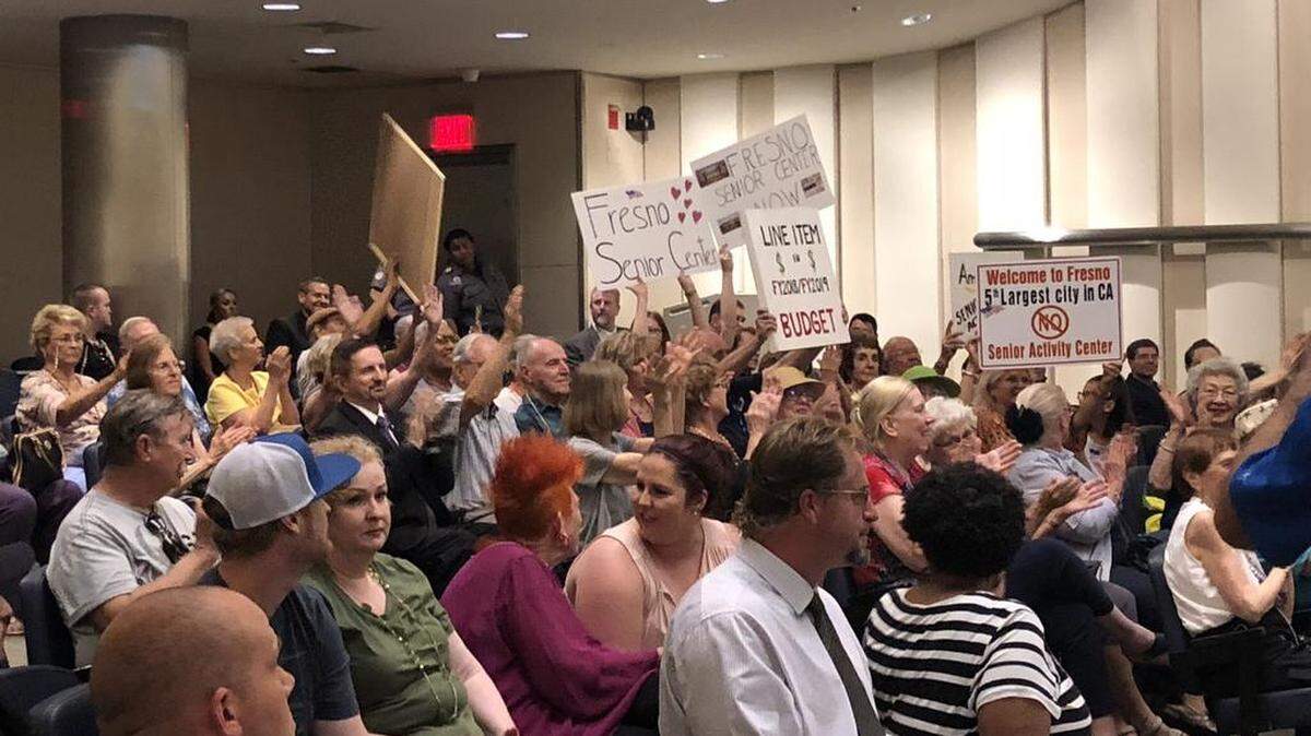 Residents wave signs to encourage the Fresno City Council to find funds to establish a senior citizens center during a June 2018 council meeting. Fresno is the fifth-largest city in the state, yet unlike many smaller communities in the county has no dedicated senior citizens center. New data shows that life expectancies in Fresno neighborhoods varies widely from one census tract to another, from about 70 years old to 85 years and up.