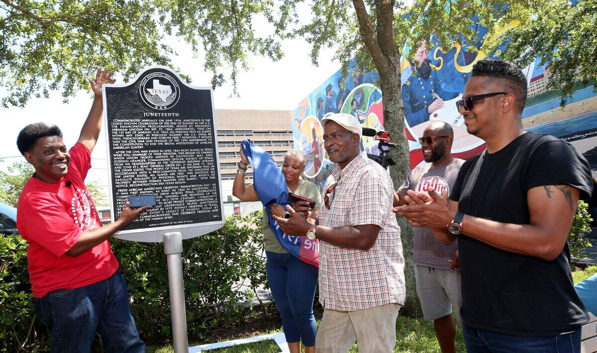 Sam Collins III, left, and others celebrate at the Juneteenth historical marker in Galveston after President Joe Biden signed the Juneteenth National Independence Day Act into law on Thursday, June 17, 2021. 