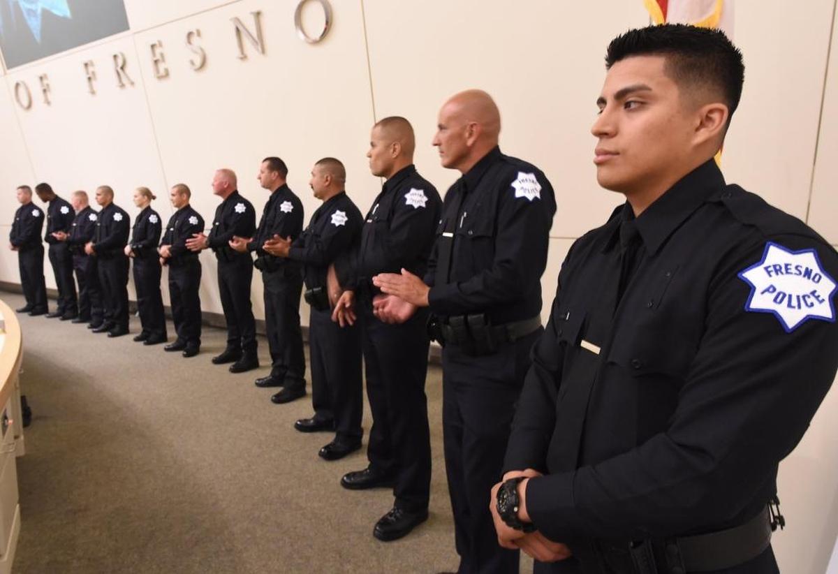 New Fresno police officer Jesus Torres, right, stands with other officers during a May 1 swearing-in and promotion ceremony at Fresno City Hall.