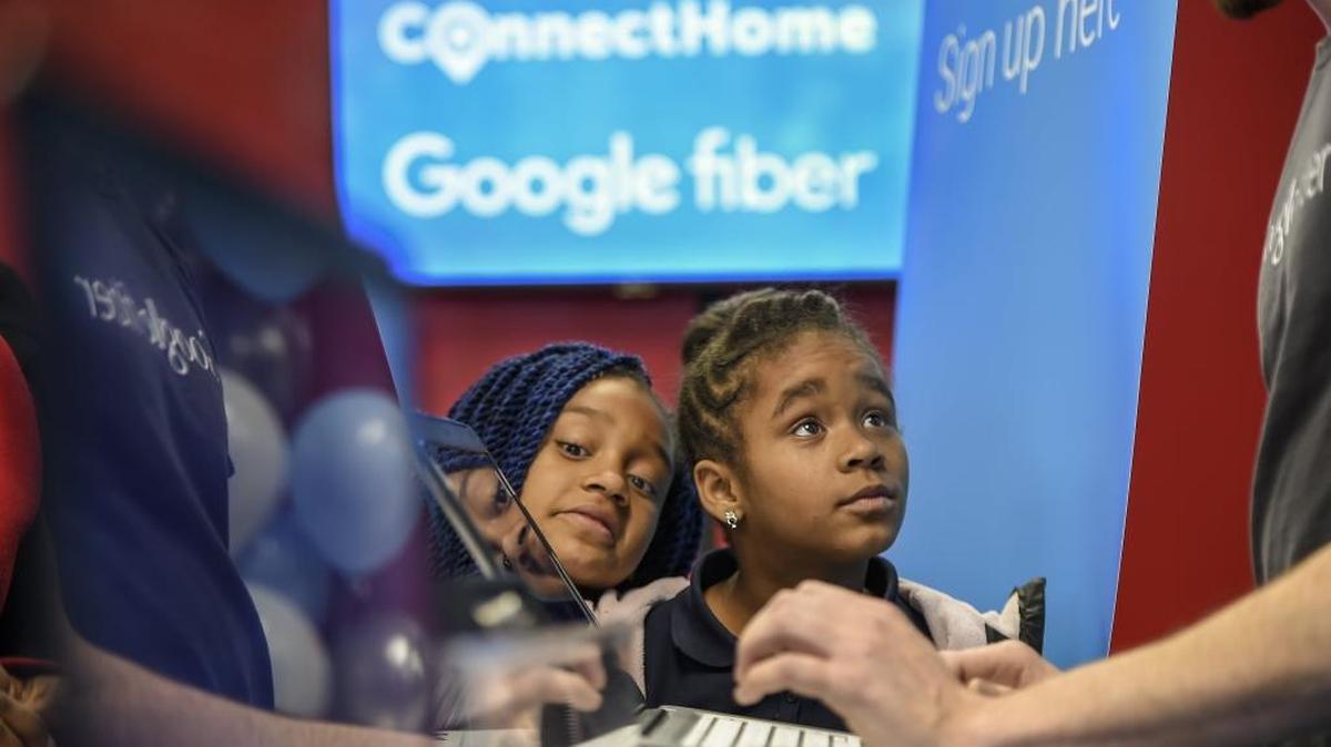 Jazmine Davis, 10, left, and her sister, Terrianna Boone, 8, watch as their mother signed up for Google Fiber service in February 2016. Kansas City, Kansas, won the Google internet challenge, beating out 1,100 other cities, including Fresno.