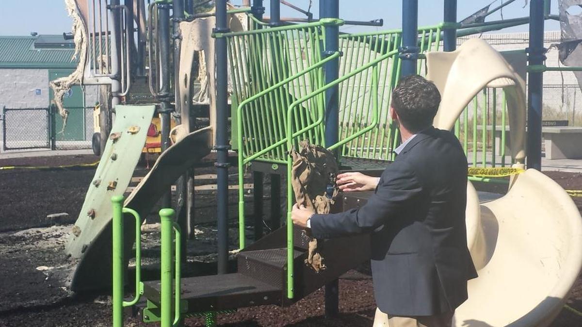 
Fresno City Council member Clint Olivier holds a piece of melted plastic, part of what’s left of the playground at Romain Park. He says the $100,000 play set will have to be replaced in the wake of a fire Sunday.
