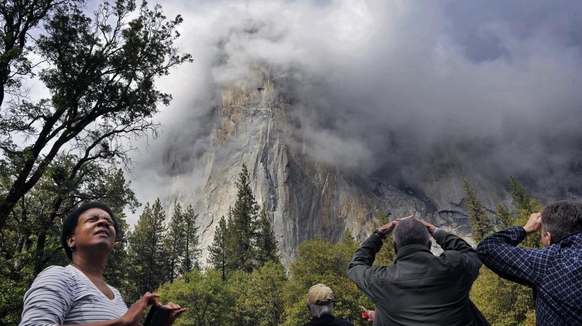 
Visitors to Yosemite Valley look toward clouds forming around El Capitan following the celebration for the 125th Anniversary of Yosemite National Park on Thursday.
