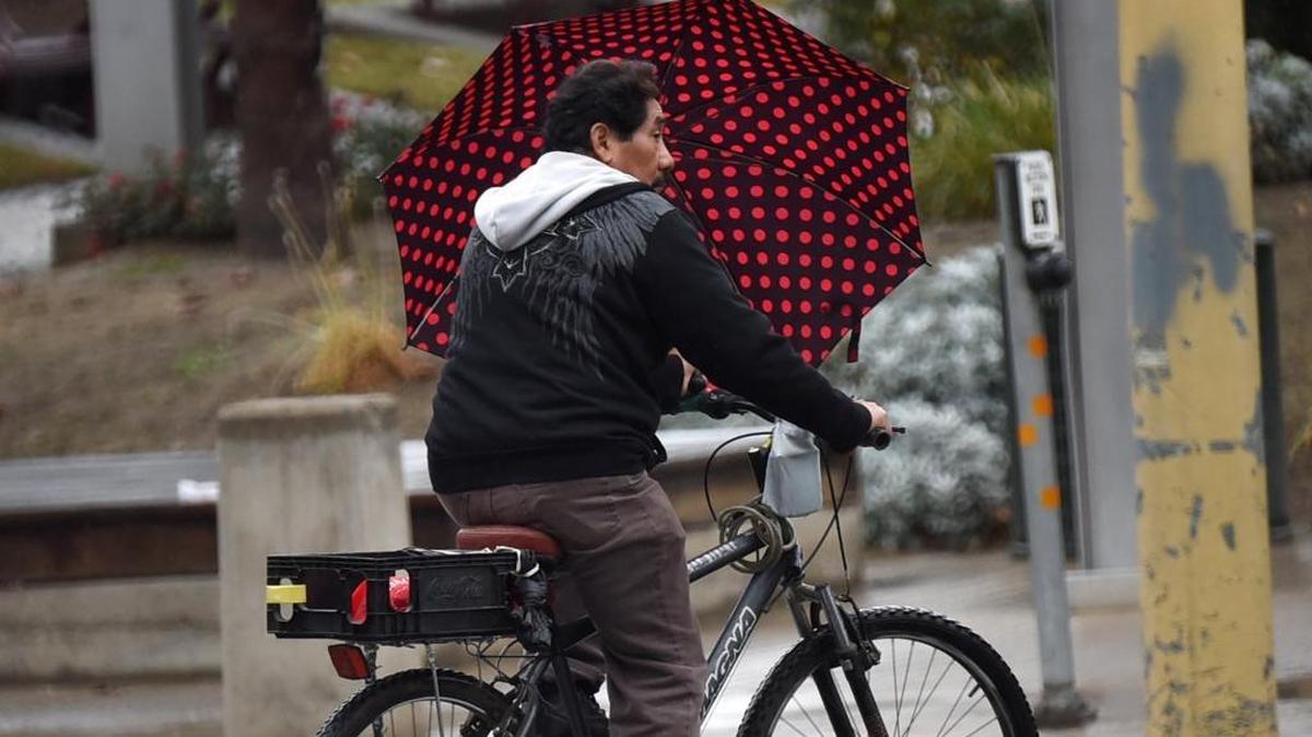 A cyclist has his umbrella handy during light showers Monday morning near the courthouse in downtown Fresno.