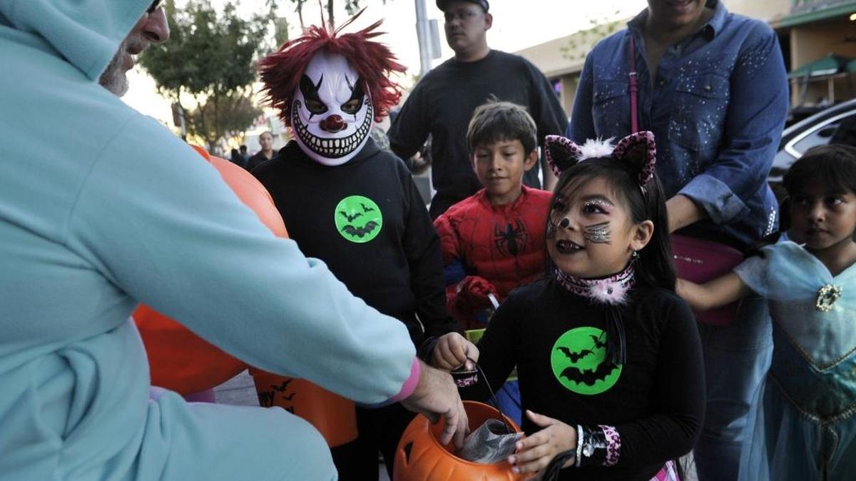Valeria Melendez receives candy from Terry Story outside FAB on Olive Avenue as people went trick or treating in the Tower District in this 2015 photo. CHP Officer Robert Montano advises drivers and pedestrians alike to be extra careful Tuesday evening.