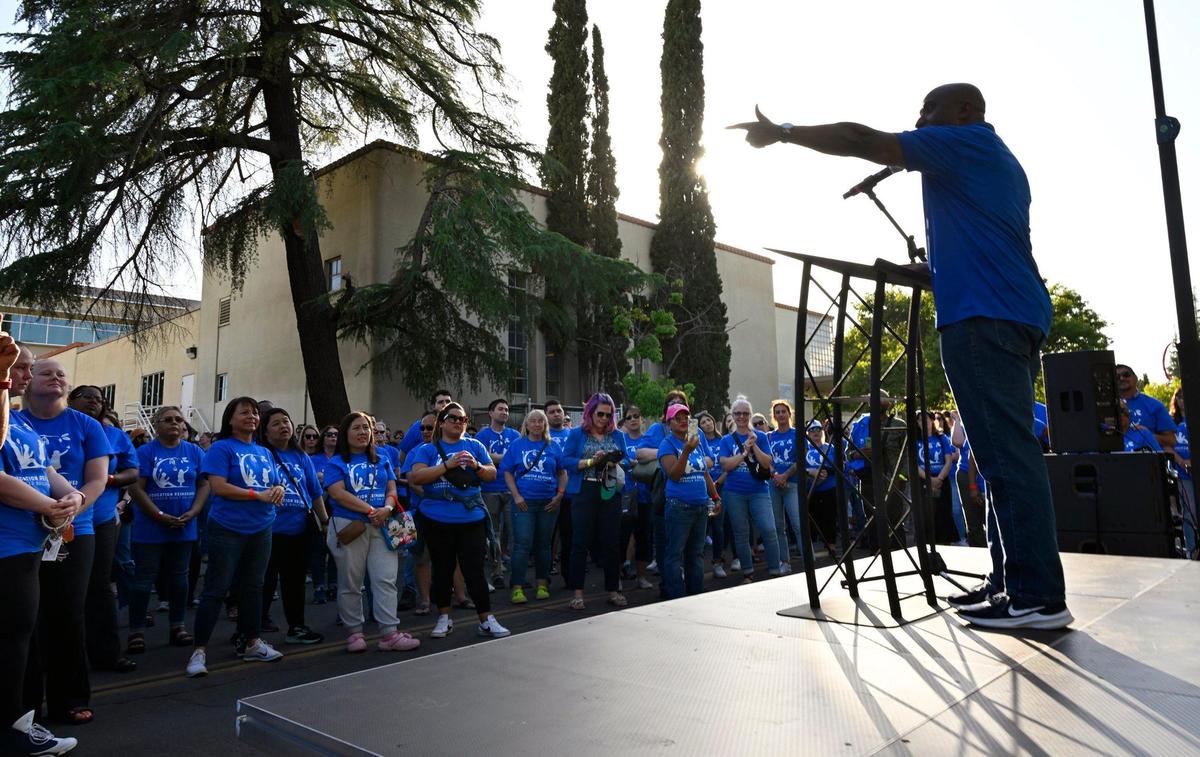 Fresno Teachers Association Executive Director Louis Jamerson addresses the crowd, right, as over a thousand teachers and supporters gathered for an Education Rally & Block Party along N Street while the Fresno Unified board met inside in downtown Fresno on Wednesday, May 24, 2023.