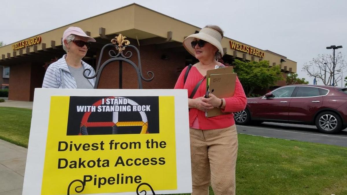Cherylyn Smith, right, the VP of Fresnans against Fracking, says the group is urging customers to close their accounts with Wells Fargo, which they say is a major investor in the Dakota Access Pipeline. Smith and two other women handed out fliers at the Shaw Avenue branch on Saturday afternoon.