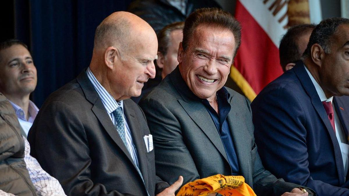 Former California Governors Jerry Brown, left, and Arnold Schwarzenegger smile as they are honored for their leadership in the accomplishment of 1 million solar roofs across the state during a ceremony at Buchanan High School in Clovis on Thursday, Dec. 12, 2019.