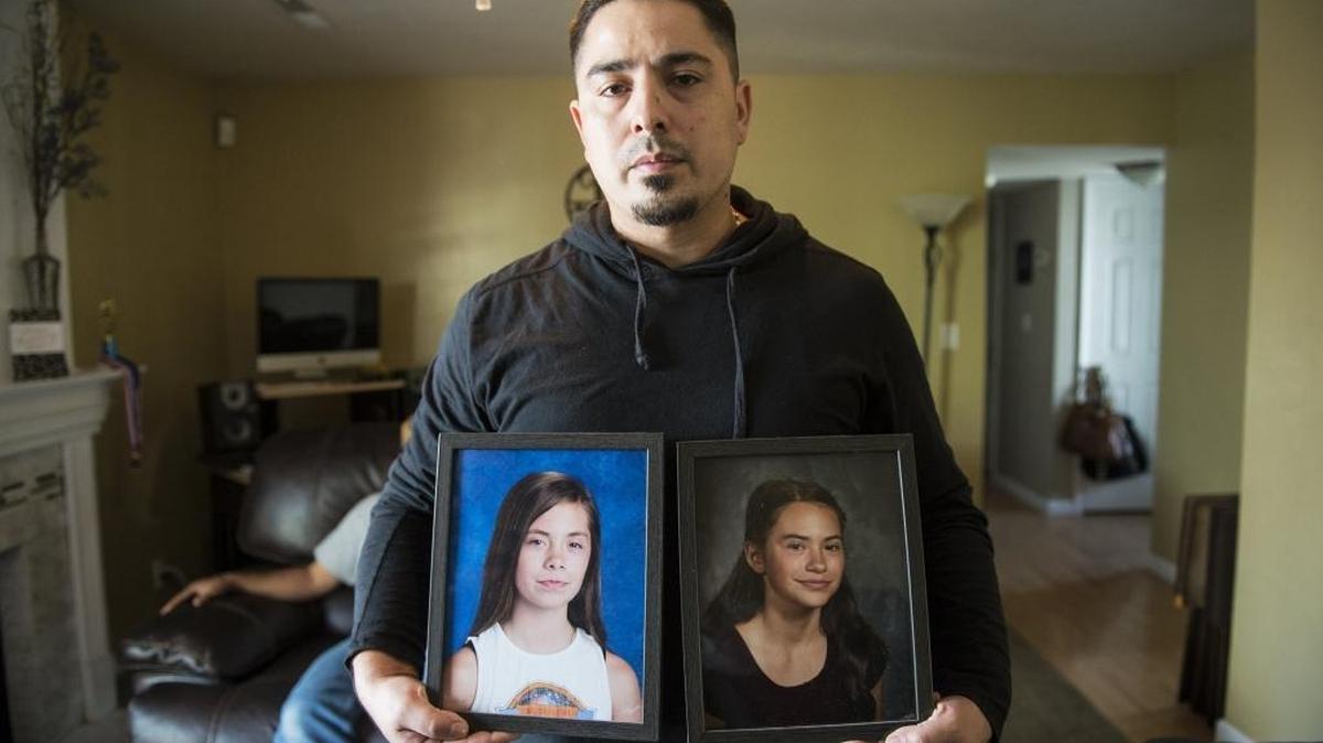 Jose Martinez, 38, holds photos of his daughters Lyza Martinez, 11, left, and Drea Martinez, 12, at his home in Merced on Tuesday.